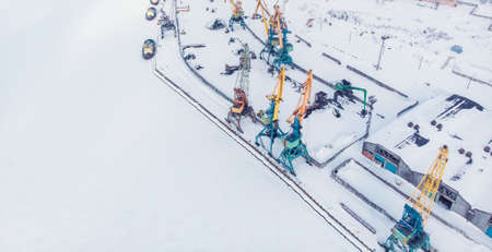 Ice bound frozen port for transshipment of coal from polar mines Container cargo ship loading North Arctic doc, top aerial viewの写真素材