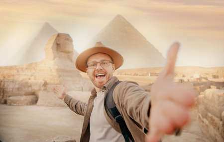 Travel Selfie photo man in hat background pyramid of Egyptian Giza and Sphinx, sunset Cairo, Egypの写真素材