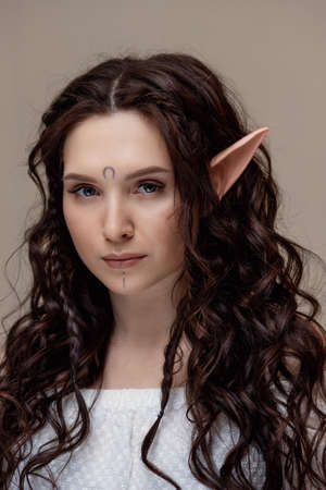 Beautiful fashion brunette woman elf with extended fake eyelashes, concept creative photography beauty industryの写真素材