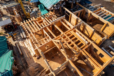 Construction industry concept. Timber wooden frame of house from bar, foundations of villas. Aerial top viewの写真素材