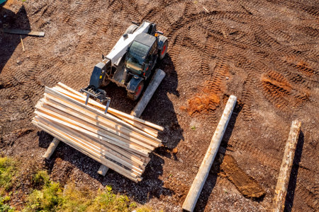 Loader works on sawmill, transporting timber and logs for export. Aerial top view
