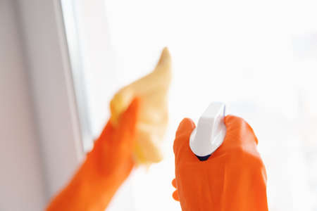 Woman washing Window glass with cleaning agent and ragの写真素材