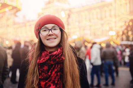 Winter portrait happy woman in wearing stylish warm clothes, background bokeh lights market. Concept travel Christmas holidays Europe cityの写真素材