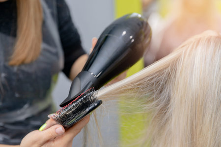 Restoration care and moisturizing of damaged hair in beauty salon by master hairdresser