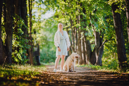 Young woman with Active, smile Happy golden retriever outdoors in grass park on sunny summer day