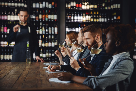 Sommeliers male and woman hold glass red wine tasting degustation cardの写真素材