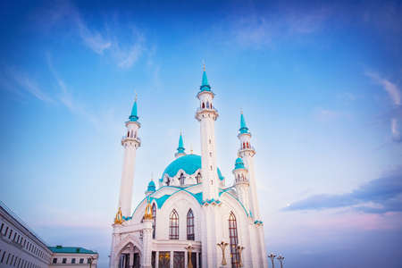 Beautiful white islamic mosque with blue roof sunset cloud with sun lightの写真素材