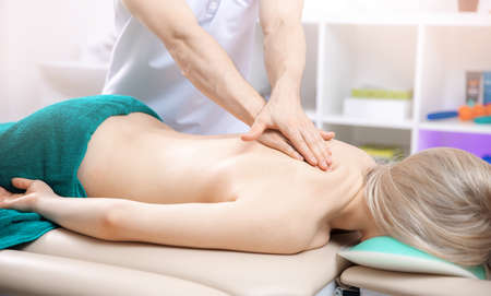 Closeup of hands male doctor osteopath massage of neck for woman in clinicの写真素材