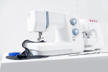 Sewing machine on table workshop of tailor white backgroundの写真素材