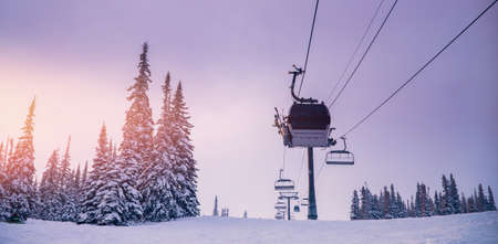 Banner landscape mountain ski lift resort in winter forest sunsetの写真素材