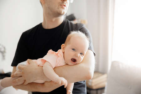 Young Father man tries to calm crying and toddler tantrum of baby girl. Concept stress parenting childの写真素材