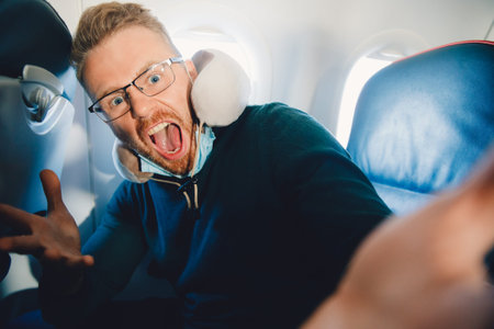 Concept of aerophobia, male tourist is afraid of flying on airplaneの写真素材