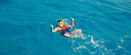 Traveler man swimmer with mask and snorkel is engaged in snorkeling in red sea, turquoise clear water bannerの写真素材