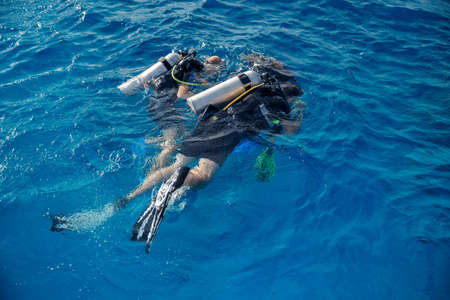 Diving training, instructor instructs tourists to dive underwater with scuba diving in sea, top viewの写真素材