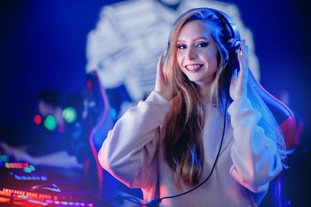 Young caucasian happy woman professional gamer win in online video game with headphones, neon backgroundの写真素材