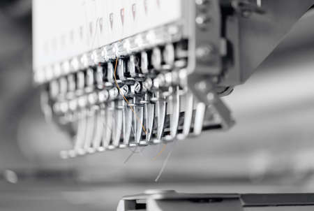 Automatic machine for embroidery patterns on fabric, background white color. Concept Interior of garment factoryの写真素材