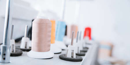 Close-up spool of multicolored threads for sewing machine. Concept Interior of garment factoryの写真素材