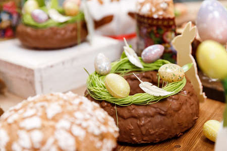Easter table orthodox sweet bread, kulich with chocolate eggs and rabbit. Variety pastries for holidayの写真素材