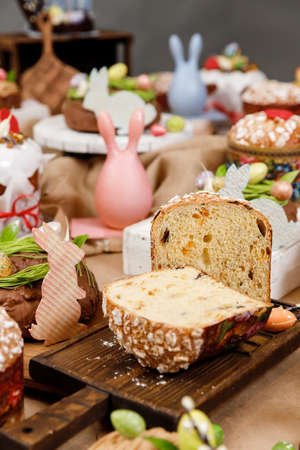 Easter table orthodox sweet bread, kulich with chocolate eggs and rabbit. Variety pastries for holidayの写真素材