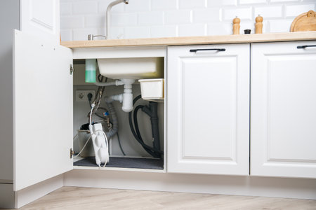 Installing and replacing filter for filtering water in apartment in white kitchenの写真素材
