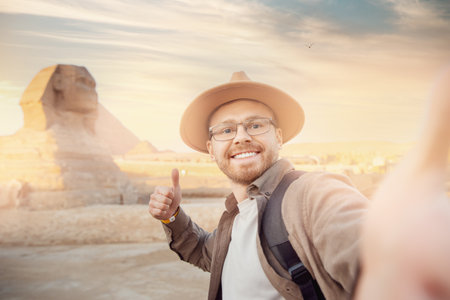 Travel Selfie photo man in hat background pyramid of Egyptian Giza and Sphinx, sunset Cairo, Egypの写真素材