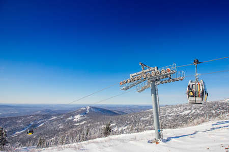 Cabin lift for sheregesh kemerovo ski resort on background of mountains and blue sky, sunny dayの写真素材