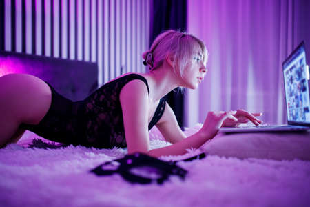 Beautiful woman webcam streamer conducts online stream only for fans, subscribers through laptop cameraの写真素材