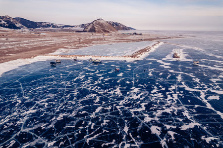 Lake Baikal winter, clear ice surface with mountains and hovercraft touristsの写真素材