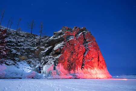 Beautiful landscape island Shaman Stone winter lake Baikal with transparent cracked blue ice. Concept travel Russiaの写真素材