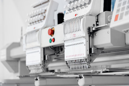 Automatic machine for embroidering patterns on fabric with threads. Concept Interior of garment...