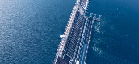 Aerial top view hydroelectric dam, water discharge through locks, blue color banner industrial conceptの写真素材