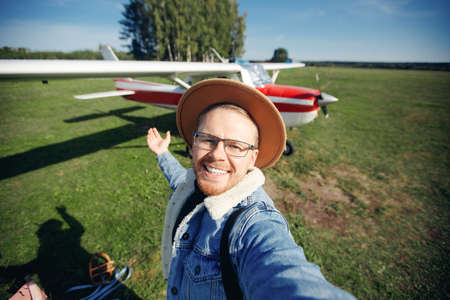 Selfie photo happy man pilot background white aircraft cockpit. Concept training private aviationの写真素材