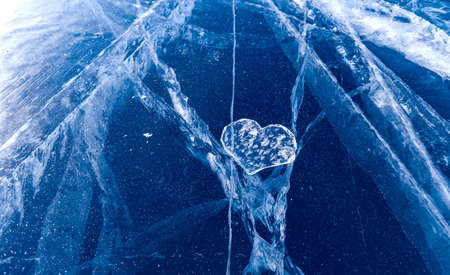 Crystal clear heart lies on surface of cracked ice of frozen Lake Baikalの写真素材