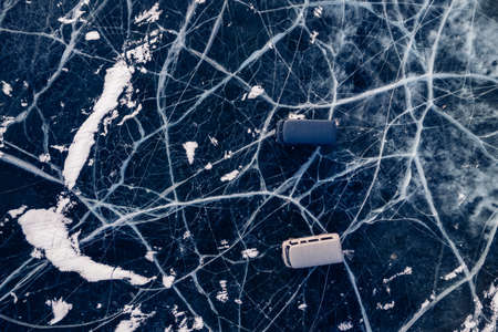 Travel winter lake Baikal. Clear ice surface with cars buses with tourists parked, aerial top viewの写真素材