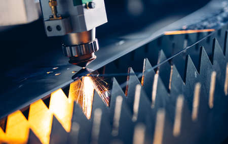 Concept technology industrial Blue color with copy space. Closeup Laser CNC cut of metal with light sparkの写真素材