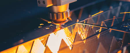 Blue color Laser CNC cut of metal with light spark, technology modern industrial bannerの写真素材