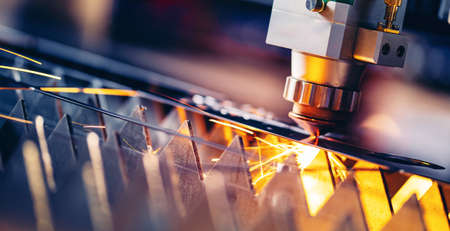 Macro CNC laser machine cutting sheet metal with light spark. Technology plasma industrial banner, Blue steel colorの写真素材