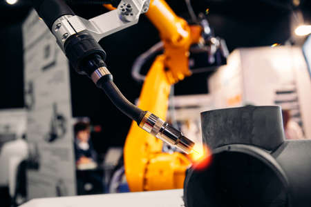 CNC automatic arm robot welding metal pipe part in industry factoryの写真素材