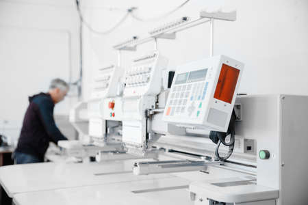 Concept Interior of garment factory. Automatic machine for embroidering patterns on fabric with threadsの写真素材