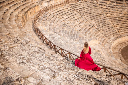 Hierapolis ancient city Pamukkale Turkey, woman in red dress background ruins sunsetの写真素材