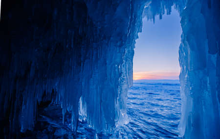 Blue Ice cave or grotto on winter lake Baikal. Beautiful winter landscape with long iciclesの写真素材
