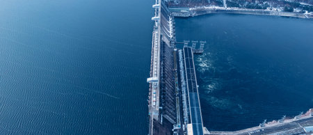 Aerial top view hydroelectric dam, water discharge through locks, blue color banner industrial...