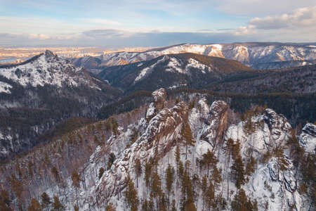 Aerial top view city Krasnoyarsk Russia taiga forest and rocks of stolby sanctuary, winter sunsetの写真素材