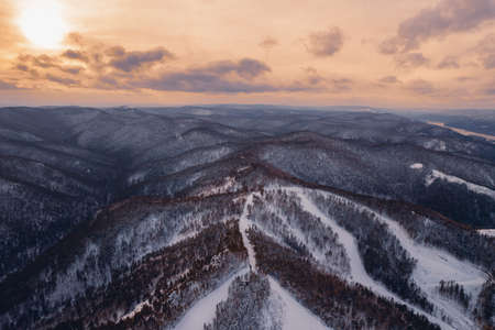 Aerial top view city Krasnoyarsk Russia taiga forest and rocks of stolby sanctuary, winter sunsetの写真素材