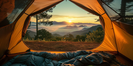 Sunrise view from inside a tent overlooking a mist covered mountain range.の素材