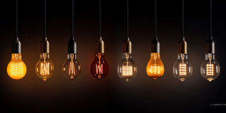 Various styles of glowing filament light bulbs against a dark backgroundの素材