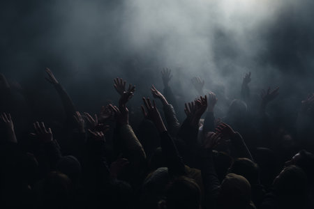 A crowd of people reaching upwards in a misty, eerie atmosphereの素材