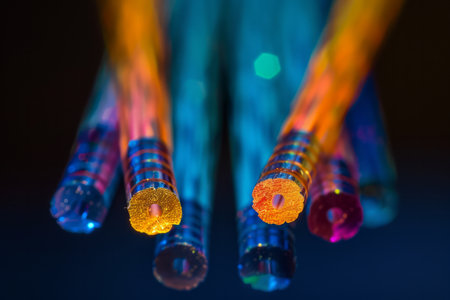 Close-up of vibrant fiber optic cables with illuminated ends against a dark background.の素材