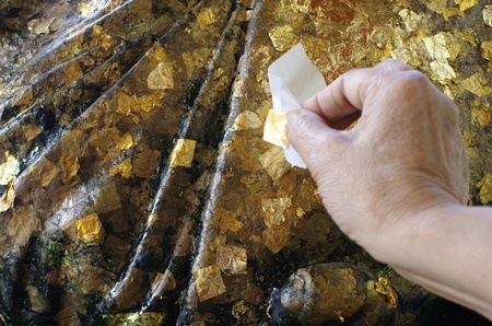 Gold Foil on Statue with Hand Stickingの写真素材