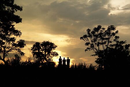 Three Men Walking in Sunset Sky の写真素材